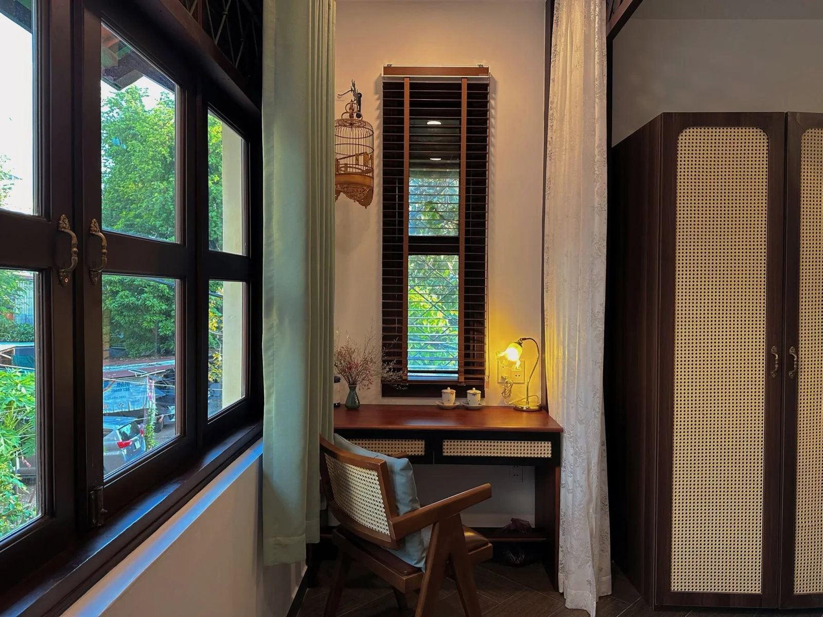 Desk nook by the wooden window with a hanging birdcage